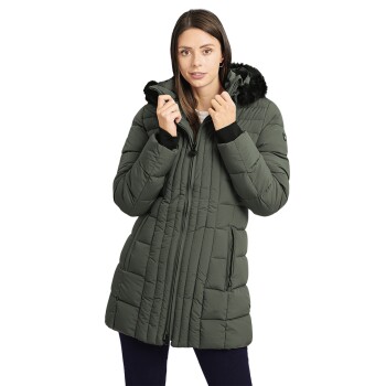 Eine Frau trägt einen stilvollen, gepolsterten grünen Wintermantel mit einer fellgefütterten Kapuze und steht mit den Händen nahe dem Reißverschluss.