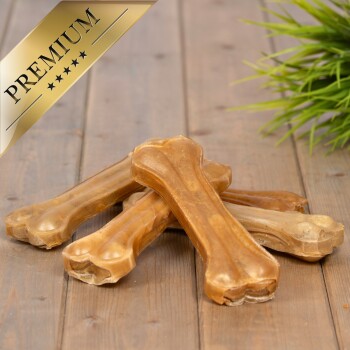 Ein Stapel von Premium-Hundekauknocken auf einer Holzoberfläche, mit einem goldenen 'PREMIUM'-Etikett in der oberen linken Ecke.