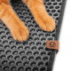 Orange-getigerte Katze in einer schwarzen, runden, automatischen Katzentoilette im Wohnzimmer; daneben sitzt eine Frau auf einem Sessel mit einer grauen Katze auf dem Schoß.