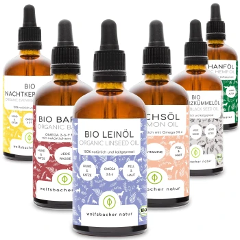 Sechs bernsteinfarbene Glasflaschen mit organischen Haustierölen, beschriftet mit Vorteilen für Hunde und Katzen, von "wolfsbacher natur."