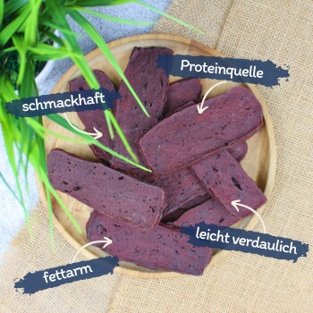 Hundeleckerlis auf einem Holzbrett präsentiert, beschriftet mit 'Leckerli', 'fettarm', 'auch für kleine Hunde' und 'gut verträglich'.
