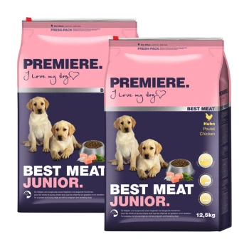 Zwei Säcke Hundefutter mit der Aufschrift "Premiere. Best Meat Junior." in einem rosa und dunkelblauen Design, mit einer Schüssel Trockenfutter und Hühnerstücken.