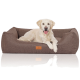 Ein Golden Retriever liegt bequem auf einem braunen Haustierbett mit einem Lederetikett, das 'HAPPY PAW' liest.