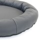 Graues Haustierbett mit runder, gepolsterter Form und glatter Oberfläche, mit einem Reißverschluss entlang der Kante für einfache Reinigung.