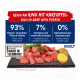 Rohe Rindfleischstücke mit Kartoffel auf einer Schieferplatte, Tierfutteretikett zeigt 93 % Fleisch, 7 % Gemüse, 0 % Getreide, hergestellt in Deutschland.