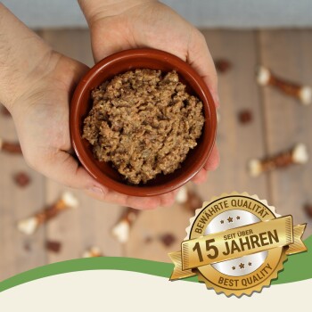 Plastikbehälter mit braunem, stückigem Tierfutter, gekennzeichnet mit "getreide- und glutenfrei," "ohne Konservierungsstoffe," "natürlich," und "hoher Fleischgehalt."