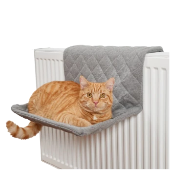 Eine orange getigerte Katze, die auf einem grauen, gesteppten Heizkörperbett liegt, das auf einem weißen Heizkörper positioniert ist.
