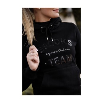 Eine Nahaufnahme einer Person, die einen schwarzen Hoodie mit dem Text "SPOOKS equestrian TEAM" in glänzender Schrift trägt.