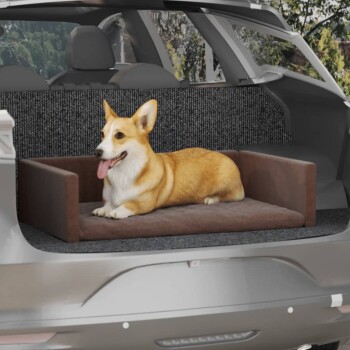 Ein glücklicher Corgi, der auf einem plüschigen Hundebett im hinteren Teil eines Autos entspannt, mit einem gemütlichen braunen Kissen und einem strukturierten grauen Hintergrund.