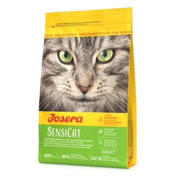 Eine Nahaufnahme des Gesichts einer Katze auf einem gelben und grünen Beutel von Josera Sensicat Katzenfutter, das die Verdaulichkeit und 89% tierisches Protein hervorhebt.