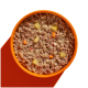 Eine Nahaufnahme einer Schüssel mit Hundefutter, die eine Mischung aus Hackfleisch, Quinoa und gewürfeltem Gemüse zeigt, vor einem orangefarbenen Hintergrund.