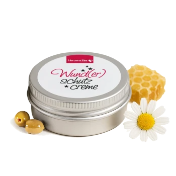 Dose der HerzensTier Wund(er)schutz Creme mit Kamillenblüte, Wabe und Oliven auf weißem Hintergrund.