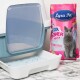 Eine Katzenstreu-Box mit einer klaren Klappe und blauen Silikakristallen, neben einer rosa Tasche mit Lyra Pet Power Silica Katzenstreu und einer grauen Katze.