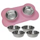 Zwei Edelstahl-Haustierschalen auf einer rosa Silikonmatte in Form eines Knochens, mit vier zusätzlichen Schalen davor.
