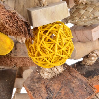 Bunter Vogelschutz mit einem gelben geflochtenen Ball, natürlichen Holzstücken und verschiedenen Texturen, ideal für die Bereicherung von Haustieren.