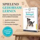 Eine Person trainiert einen Hund mit einer Leine in einem grasbewachsenen Bereich, neben einem eBook mit dem Titel 'Die Arbeit mit der Reizangel', das Trainingstipps enthält.