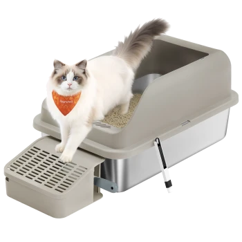 Ragdoll-Katze mit orangefarbigem 'Feandrea'-Halstuch steht auf einer beigen, geschlossenen Katzentoilette mit Siebwanne und befestigter Schaufel.