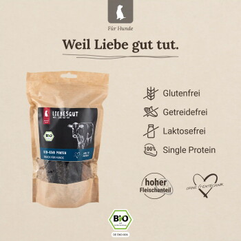 Kraftpapierbeutel mit Liebesgut Bio‑Rinderpansen-Hundesnacks mit Kuhabbildung; deutscher Text ‚Für Hunde‘ und ‚Weil Liebe gut tut.‘; Symbole: Glutenfrei, Getreidefrei, Laktosefrei, Single‑Protein, BIO