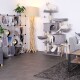 Ein gemütliches Wohnzimmer mit einem grauen Katzenbaum und vier weißen Katzen, die spielen, sowie einem modernen Bücherregal und einer Stehlampe.