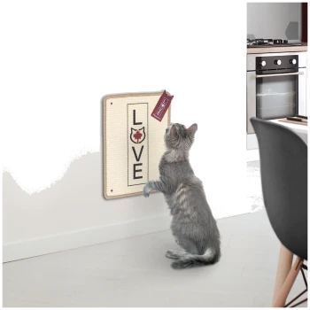 Eine verspielte graue Katze, die nach einem wandmontierten Kratzbrett greift, auf dem 'LOVE' steht, mit einem kleinen Anhänger.