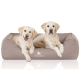Zwei Golden Retriever Welpen sitzen zusammen auf einem gemütlichen, beigen Hundebett mit dem Logo "KNUFFELWUFF", das prominent angezeigt wird.