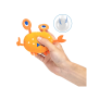 Eine Person hält ein leuchtend orangefarbenes, krabbenförmiges Plüschtier mit blauen Akzenten, mit einem Quietscher im Inneren.