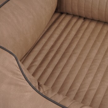 Eine Nahaufnahme eines plüschigen, beige-farbenen Haustierbettes mit einem gerippten Innenraum und weichen, gepolsterten Seiten, entworfen für den Komfort von Haustieren.