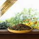 Eine Holzschüssel mit dunklem Haustierfutter liegt auf einer Oberfläche, umgeben von grünen Pflanzen und gelben Blumen, mit einem goldenen Banner "PREMIUM".