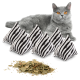Eine graue Katze mit leuchtend orangefarbenen Augen liegt neben fünf gestreiften Katzenminzkissen und einem Haufen getrockneter Katzenminzblätter.