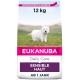 Eukanuba Daily Care Hundefutterbeutel, 12 kg, mit einem weißen Hund auf Gras, beschriftet mit "Sensible Haut" und "AB 1 JAHR."