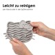 Eine hellgraue Katze leckt eine rosa, uhu-förmige Silikonmatte mit der Aufschrift "Rutschfest & flexibel", die ihre rutschfesten Eigenschaften hervorhebt.