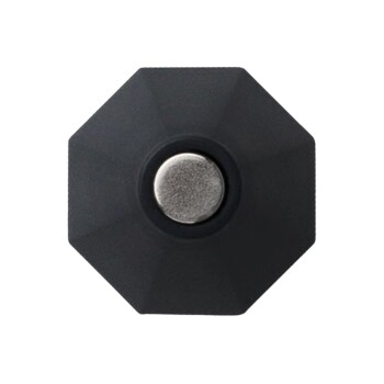 Schwarzes achteckiges Haustierspielzeug mit einem zentralen metallischen Knopf, entworfen für interaktives Spielen.