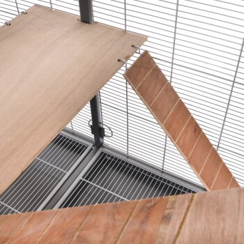 Holzregale und Rampen in einem Haustierkäfig, mit Metallgitterseiten und einem sauberen, geräumigen Bodenbereich.
