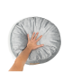 Eine Hand drückt auf ein weiches, rundes graues Haustierbett mit einem gepolsterten Design, das seine plüschige Textur zeigt.