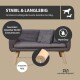 Ein modernes graues Haustiersofa mit Holzbeinen und zwei kleinen Kissen, auf Holzboden neben einem schwarzen Stuhl und einem wandmontierten Pflanzenfoto.