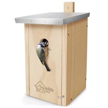 Ein Holzvogelhaus mit einem Metalldach, in dem ein Blaumeise aus dem Eingang schaut, und das Logo 'wildlife home' an der Seite eingraviert.