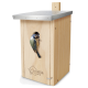 Ein Holzvogelhaus mit einem Metalldach, in dem ein Blaumeise aus dem Eingang schaut, und das Logo 'wildlife home' an der Seite eingraviert.