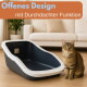 Getigerte Katze neben offener Katzentoilette (weißer Rand) im Wohnzimmer. Sichtbarer Text: Offenes Design, mit durchdachter Funktion