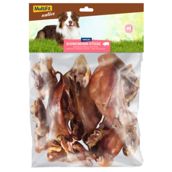 Eine durchsichtige Tüte mit "MultiFit native Snacks" Schweineohrstücken mit dem Etikett "SCHWEINEOHR-STÜCKE" und einem braun-weißen Hund im Hintergrund.