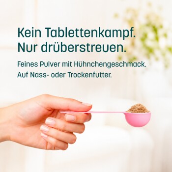 Hand hält rosa Messlöffel mit braunem Pulver; Text: ‚Kein Tablettenkampf. Einfach drüberstreuen. Hähnchengeschmack, für Nass- oder Trockenfutter.‘