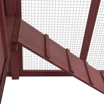 Holzrampe, die zu einem Haustiergehege führt, mit einem Gitterdrahtoberteil für Belüftung und Sicherheit.