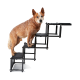 Ein Hund steht auf einer mehrstufigen Haustiertreppe, mit einer schwarzen Tragetasche mit dem Etikett "plupet" und gefalteten Stufen daneben.