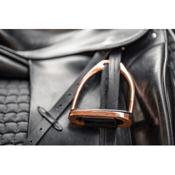 Nahaufnahme eines schwarzen Ledersattels mit einem glänzenden Kupfersteigbügel, der mit "EQUINATE" an einem schwarzen Riemen befestigt ist.