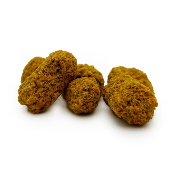 Ein Cluster kleiner, strukturierter, brauner Haustierfutterstückchen auf einem weißen Hintergrund, die natürlichen Leckereien für Haustiere ähneln.