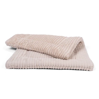 Eine weiche, beige Haustierdecke mit gerippter Textur, teilweise über einer flachen Decke desselben Designs gefaltet.