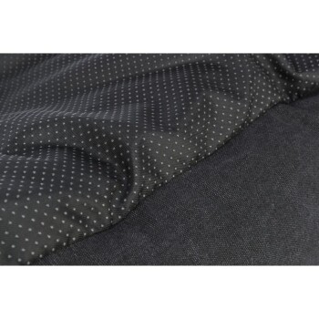 Nahaufnahme eines Haustierbettes mit einem strukturierten schwarzen Stoff mit kleinen weißen Punkten, das sein weiches und gemütliches Design zeigt.