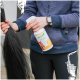 Person hält eine Flasche mit der Aufschrift ‚Stiefel Top Shine‘ und einen langen schwarzen Pferdeschweif, trägt eine marineblaue Jacke.