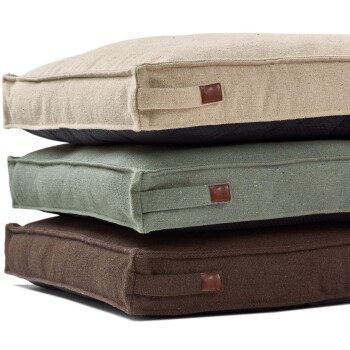 Gestapeltes Set aus drei rechteckigen Haustierbetten in Beige, Salbeigrün und Braun mit Seitengriffen und kleinen braunen Lederetiketten.