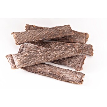 Ein Haufen zähe, strukturierte Hundeleckerlis in langen Streifen, die eine reichhaltige braune Farbe und eine leicht raue Oberfläche zeigen.