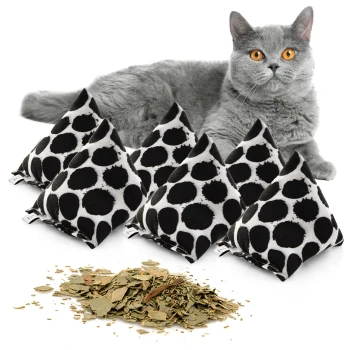 Eine graue Katze mit orangefarbenen Augen sitzt neben fünf dreieckigen, gepunkteten Katzenminze-Spielzeugen und einem Haufen getrockneter Katzenminzblätter.